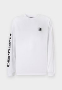 Hvid langærmet t-shirt lavet af bomuld, med en lille sort logo-lap på brystet og fed sort tekst langs venstre ærme.