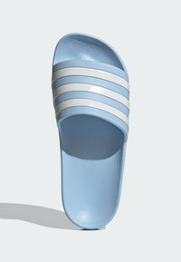Light blue slide sandal with three white horizontal stripes, smooth texture, open toe design, and a slightly contoured sole.