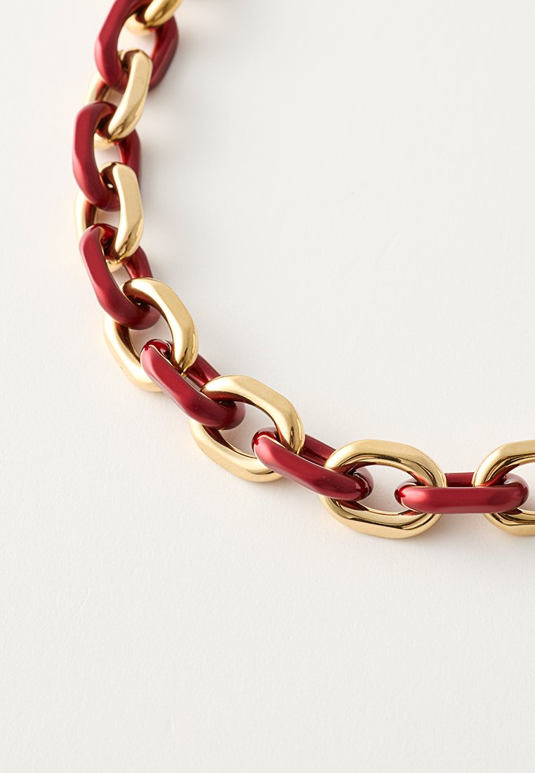 Czerwono-złoty naszyjnik łańcuszkowy z przeplatającymi się ogniwami, z błyszczącego czerwonego plastiku i polerowanego złotego metalu.