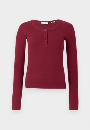 Burgundy long-sleeved top with a ribbed texture, rounded neckline, and three-button placket at the chest.