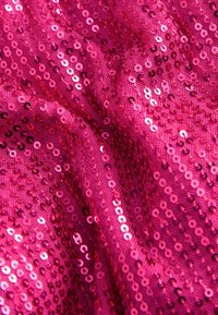 Tessuto fucsia con paillettes, dalla superficie liscia, caratterizzato da piccole paillettes circolari che riflettono la luce, creando un effetto scintillante.