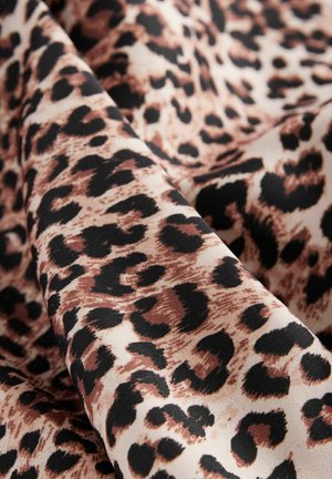 Látka s leopardím vzorem, která obsahuje směs černých skvrn na krémovém pozadí, s hladkou texturou a měkkým splývavým efektem.