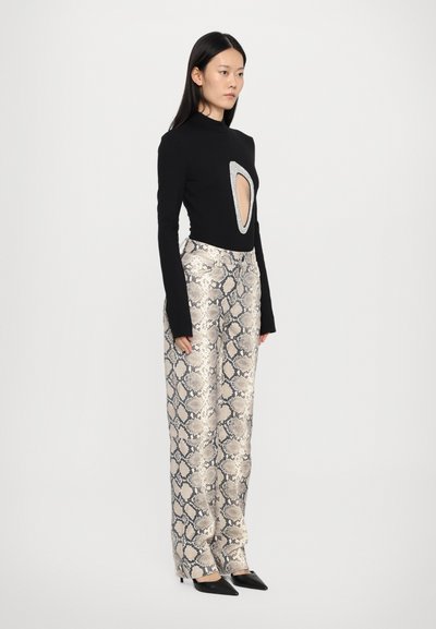 Black long-sleeve top with a cut-out detail and silver accent, paired with wide-leg pants featuring a shiny snake print pattern.
