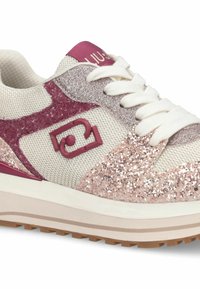 Baskets avec une tige en mesh crème, des accents pailletés roses et un logo bordeaux. Elles présentent des lacets blancs et une épaisse semelle extérieure en caoutchouc.