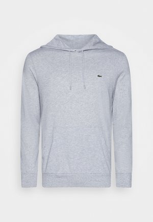 Jasnoszara bluza z kapturem, z przednią kieszenią i sznurkami. Na piersi znajduje się małe zielone logo. Wykonana z miękkiego, teksturowanego materiału.