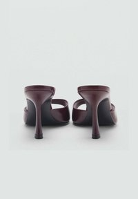 Bordeauxfarbene High-Heels-Mules mit glatter Lackoberfläche, offener Rückseite und schlanker Absatz; schwarze Sohle mit minimalistischem Design.