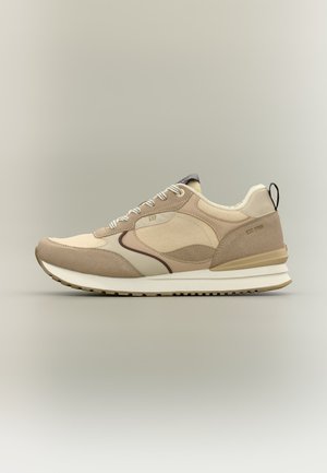 Sneaker beige e marrone chiaro con suola bianca, pannelli in mesh e suede, lacci, logo "GAP" vicino ai lacci e scritta "EST. 1969" sul tallone.