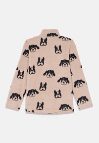 Pull en polaire beige avec un motif répété de visages de chiens noirs. Comprend des manches longues et un col montant. Texture douce.