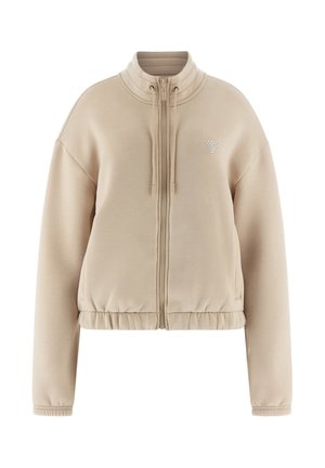 Beżowa bluza zip-up z dopasowaną talią, wysokim kołnierzem i prążkowanymi detalami przy dekolcie i mankietach. Posiada mały graficzny akcent na klatce piersiowej.