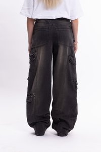 Pantalones cargo negros holgados con múltiples bolsillos grandes, textura desvanecida y un ajuste suelto. Presenta cierres de botón y broche en el lateral.