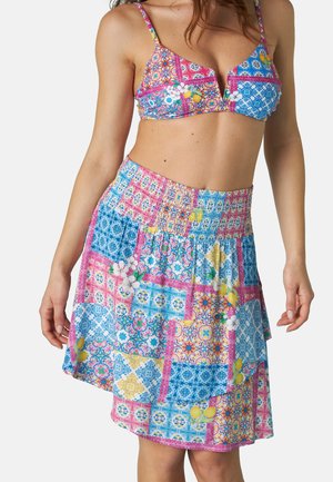 Top di bikini multicolore con motivi floreali e geometrici; abbinato a una gonna asimmetrica coordinata con vita arricciata e colori vivaci.