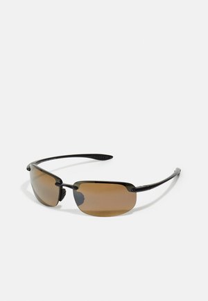 Óculos de sol com armação de metal preto e lentes castanhas. Design fino com uma forma geométrica distinta e hastes texturizadas para melhor aderência.