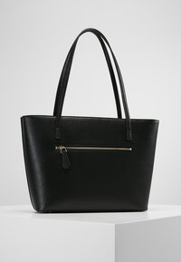 Czarna torebka typu tote z syntetycznej skóry, z dwoma uchwytami, w strukturalnym kształcie, z przednią kieszenią na zamek i srebrnymi detalami. Gładka faktura z minimalnymi akcentami.