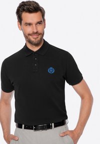 Černé polo tričko s límečkem, se třemi knoflíky a modrou vyšívanou nášivkou na levé straně hrudi. Hladká textura, krátké rukávy.