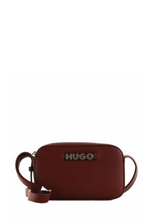 Sac bandoulière en simili cuir bordeaux, de forme rectangulaire, avec un accent logo en argent, une fermeture éclair et une bandoulière réglable.