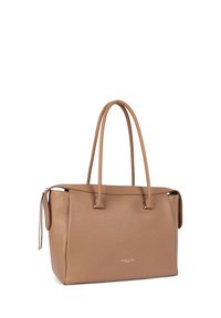 Sac fourre-tout en cuir fauve avec deux longues poignées, fermeture éclair et texture subtile. Présente un logo doré sur le devant.