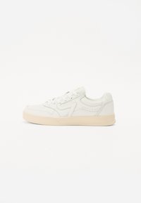 White leather sneaker with a low top design, textured toe cap, and subtle perforations on the sides. Light tan rubber sole.