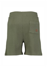 Achteraanzicht van olijfgroene, gestructureerde gebreide shorts met een elastische tailleband en een enkele patchzak aan de rechterkant.