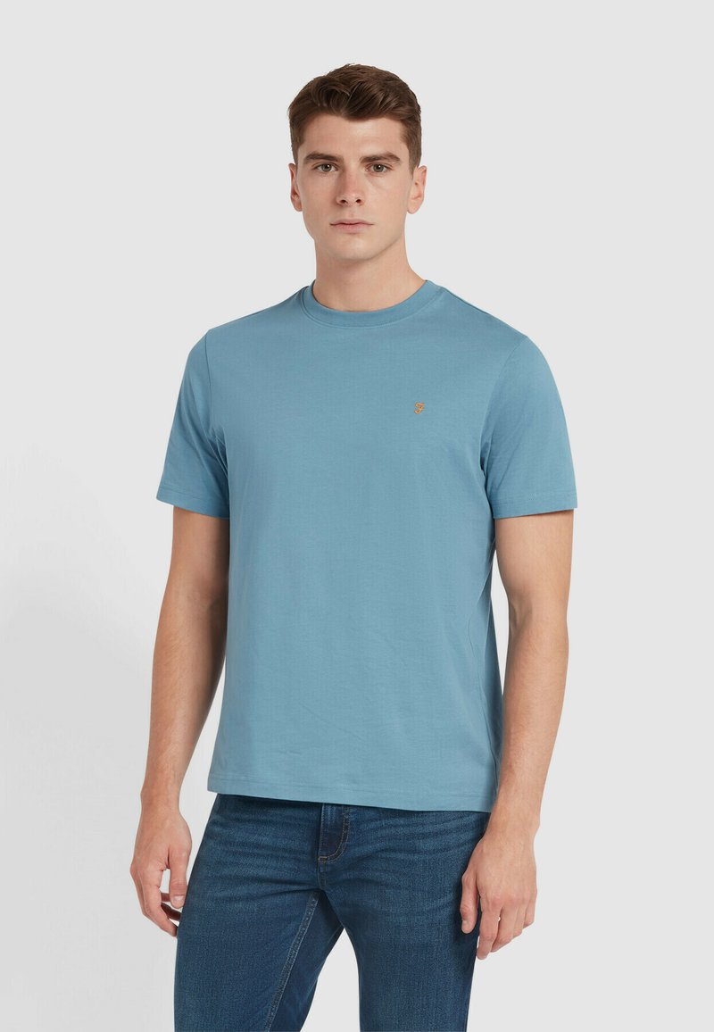 T-shirt in cotone azzurro chiaro con collo rotondo classico, maniche corte e un piccolo logo ricamato sul lato sinistro del petto.