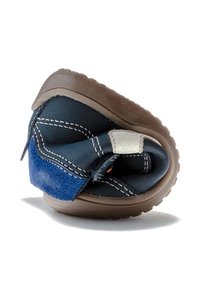 Zapato infantil flexible en azul oscuro y marrón doblado por la mitad para demostrar su suela blanda y plegable, así como el material superior flexible.