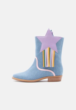 Stivaletto alla caviglia in denim con un accento a stella lavanda e frange multicolori. Presenta un contorno rosa e un tacco in legno marrone chiaro.
