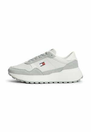 Hvid og grå lavtop sneaker med tyk sål, snørebånd foran og lille rød, hvid og blå flaglogo på siden.
