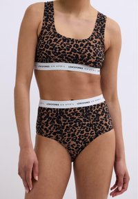 Ensemble soutien-gorge imprimé léopard et culottes taille haute. Tissu doux avec une ceinture noire arborant le texte "LOVE STORIES O H APRIL". Décolleté carré et larges bretelles.