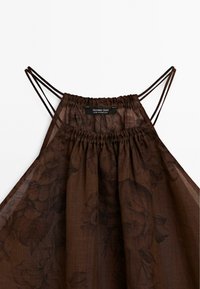 Robe fleurie marron transparente avec encolure froncée et double bretelle fine, étiquetée Massimo Dutti, fabriquée au Portugal.