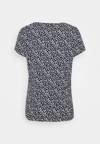 Námořnická blůza s bílým tečkovaným vzorem, krátké rukávy, kulatý výstřih a volný střih. Vyrobena z lehké, strukturované látky.