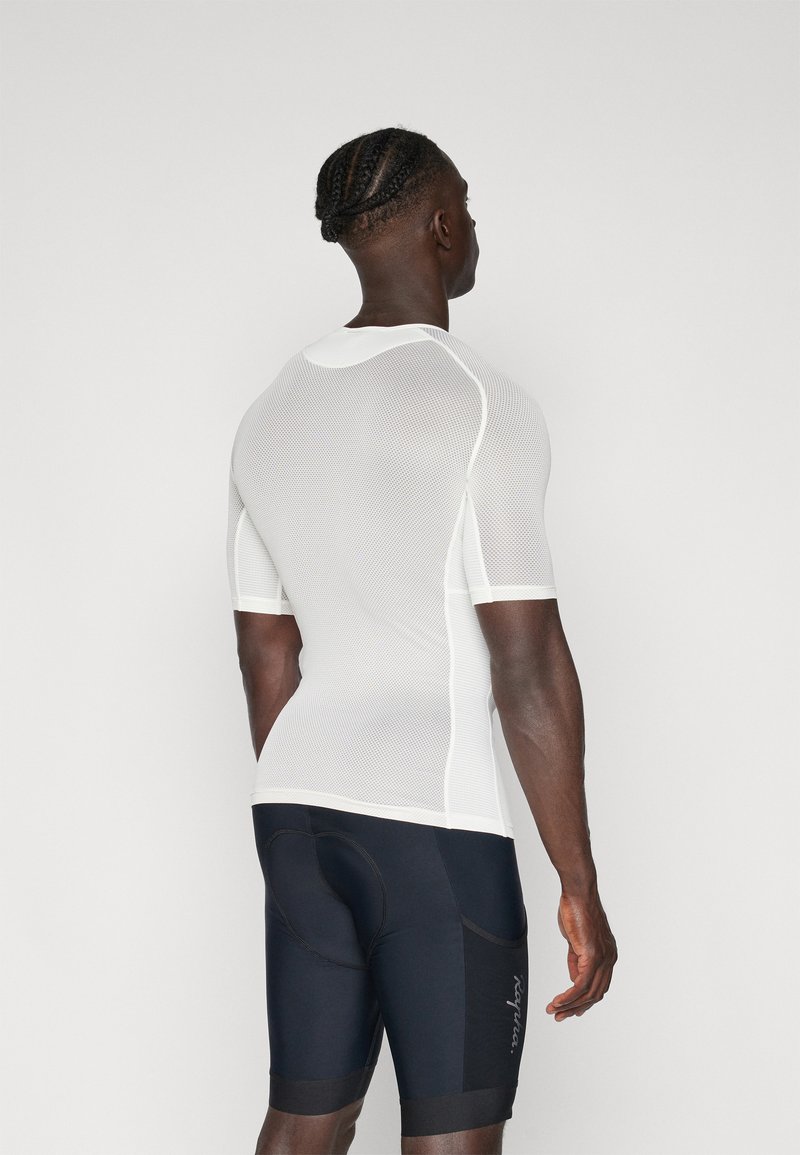 T-shirt de sport blanc à manches courtes en mesh avec un design ajusté, accompagné de shorts de cyclisme noirs ajustés avec des accents de logo blancs.