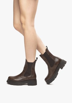 Brown leather ankle boots with elastic side panels and a chunky black sole. Features a smooth texture with a sleek design.