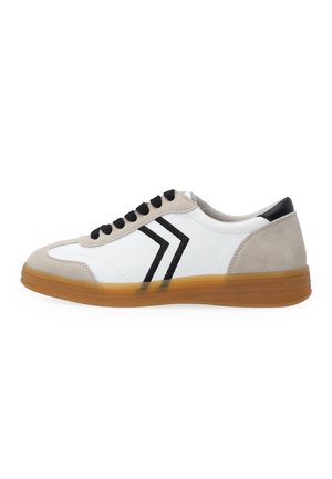 White low-top sneaker with beige suede details, black laces, black chevron stripes on side, and a translucent brown rubber sole.