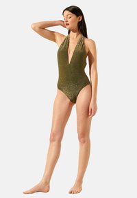 Maillot de bain une pièce en vert olive brillant avec un décolleté en V plongeant et un design à col halter, mettant en valeur une silhouette ajustée et un tissu texturé.
