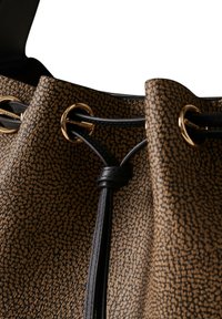 Sac en cuir marron texturé avec un cordon noir tissé à travers des œillets dorés, présentant un détail de nœud au centre.