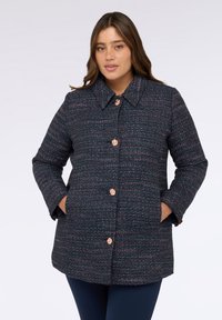 Marineblauer Tweed-Mantel mit geradem Schnitt, großem Kragen und Akzenten aus rosa und silbernem Faden. Mit runden, roségoldenen Knöpfen und Seitentaschen.