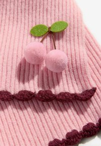 Ružová rebrovaná látka s bordovými vlnkovanými detailami. Obsahuje dve ružové pom-pom čerešne a zelené plsťové listy pripevnené na vrchu.