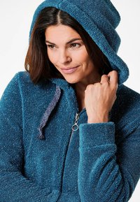 Teal kleurige capuchon sweatvest met een ritssluiting, gemaakt van gestructureerde fleece met metallic stofdeeltjes. Het heeft een lusvormige ritssluiting en een contrasterend trekkoord.