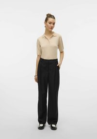 Bežna polo majica s kratkimi rokavi z detajlom gumbov, v kombinaciji s črnimi širokimi hlačami z naborki in stranskimi žepi; gladke teksture, sproščen stil.