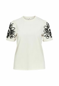 Krämfärgad t-shirt med korta, puffiga ärmar som har detaljerad svart blommig broderi på axlarna. Mjukt bomullsmaterial.