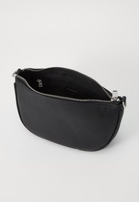Custodia in pelle nera con superficie testurizzata, forma curvata e chiusura con zip argentata. L'interno presenta una tasca e una fodera liscia.