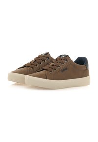 Zapatillas casual marrones con un upper texturizado, diseño de cordones, acento en el talón en negro y una suela de goma beige claro.