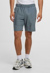 Pánské šortky do poloviny stehna z lehkého modrého materiálu s elastickým pasem, vybavené bočními kapsami a logem na levém stehně.