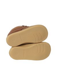 Braune Wildleder-Stiefeletten mit einer strukturierten, tanfarbenen Gummisohle, die ein gepunktetes Muster aufweist, runder Zehenpartie und dekorativen Reißverschlussdetails an der Seite.