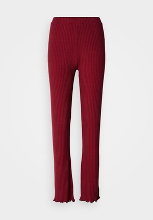 Leggings rossi a coste con un design aderente, texture morbida, orlo svasato e vita elastica per il massimo comfort.
