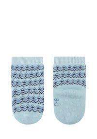 Hellblaue Socken mit einem Zickzackmuster in Marineblau und dunkleren Farbtönen, mit strukturierten Sohlen für besseren Halt. Gerippter Saum oben.