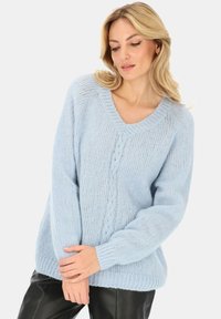 Jasnoniebieski sweter dziany z dekoltem w serek, długimi rękawami i wzorem w warkocz na przodzie, wyróżniający się miękkim, teksturowanym materiałem.