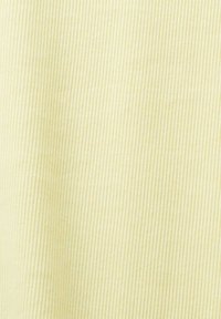 Tissu en jaune clair avec une texture à nervures verticales. Le tissu doux crée un motif subtil, renforçant la profondeur visuelle.