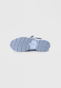 Blue sneaker sole with textured tread, featuring "JORDAN" branding and a smooth, light blue accent near the midsole.