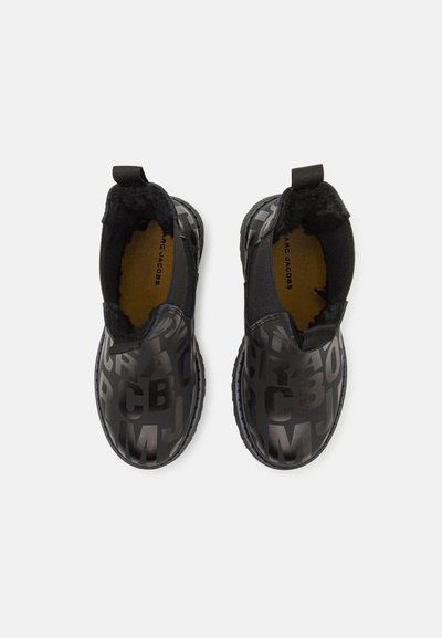 Sorte ankelstøvler med en blank overdel og et dristig forhøyet bokstavmønster, elastiske sidepaneler og teksturerte gummisåler.