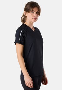 Zwarte sportieve T-shirt met korte mouwen en V-hals, gemaakt van vochtafvoerende stof. Voorzien van reflecterende accenten op de schouder.
